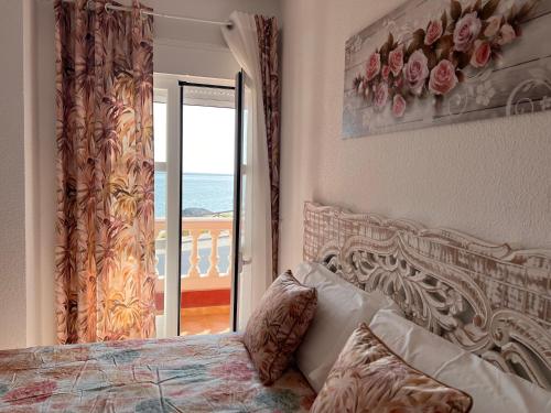 een slaapkamer met een bed en uitzicht op de oceaan bij Estudios Costavigía Mazagón by Ramona in Mazagón