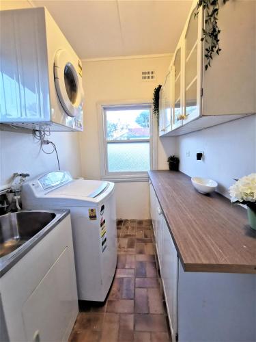 a small kitchen with a sink and a dishwasher at Sydney Meets Miranda, Comfy 4 Bedrooms Corner House in Miranda