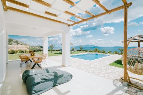 a patio with a table and chairs and a swimming pool at The Three Graces in Antimácheia