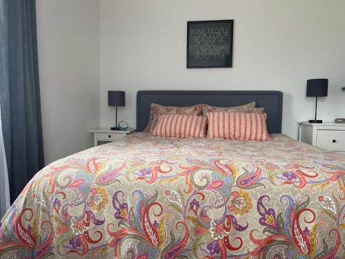 1 cama con edredón colorido y 2 almohadas en Haus Schwaighof, en Arzl im Pitztal