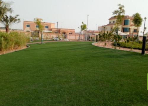 a large field of grass with buildings in the background at Fabulous Luxury Room in Abu Dhabi