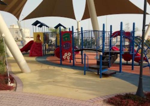 a playground with a slide and an umbrella at Fabulous Luxury Room in Abu Dhabi
