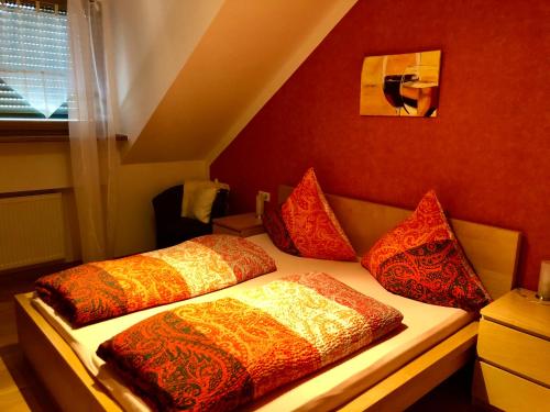 two beds in a room with red walls at Kappes-Koppelkamm in Zeltingen-Rachtig