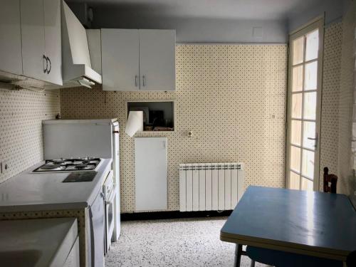 - une cuisine avec des appareils électroménagers blancs et une table dans l'établissement Tutto Mio, à Villeneuve-lès-Avignon