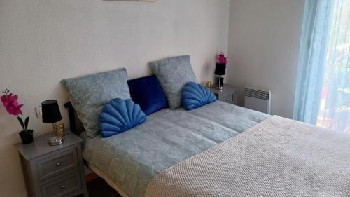 カネ・アン・ルシヨンにあるAppartement vue Mer et Port Canet en Roussillonのベッドルーム1室(青い枕のベッド1台付)