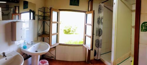 a bathroom with two sinks and a window at Surfhousegerra in San Vicente de la Barquera
