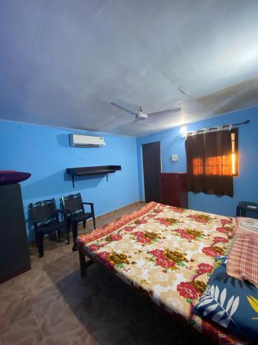 ein Schlafzimmer mit einem Bett in einem Zimmer mit blauen Wänden in der Unterkunft Castello's Coco Huts in Benaulim