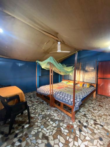 ein Schlafzimmer mit einem Bett in einem blauen Zimmer in der Unterkunft Castello's Coco Huts in Benaulim