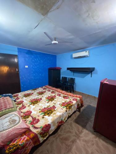 ein Schlafzimmer mit einem Bett in einem Zimmer mit blauen Wänden in der Unterkunft Castello's Coco Huts in Benaulim