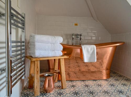 a bathroom with a wooden tub with towels on it at Halwell Lodge in St Ives