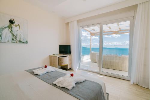 a bedroom with a bed with a view of the ocean at The Three Graces in Antimácheia