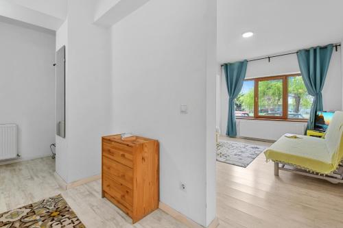 uma sala de estar com uma cadeira amarela e uma cómoda em homestay em Otopeni