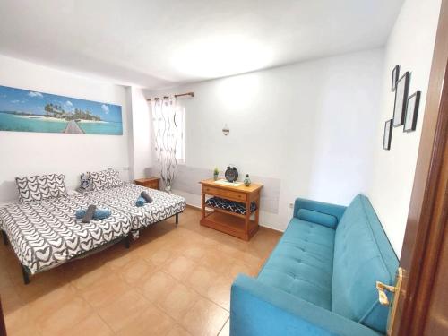 sala de estar con sofá azul y mesa en Casa Daria - WiFi - swimming pool - FuerteventuraBay en Costa de Antigua