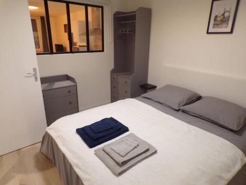 une chambre avec un lit avec deux serviettes dessus dans l'établissement Appartement 2/4 pers, 44m2, hypercentre., à Lons-le-Saunier