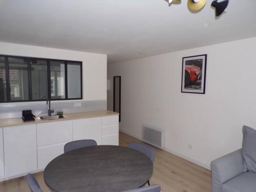 un salon avec une table et une chaise dans l'établissement Appartement 2/4 pers, 44m2, hypercentre., à Lons-le-Saunier