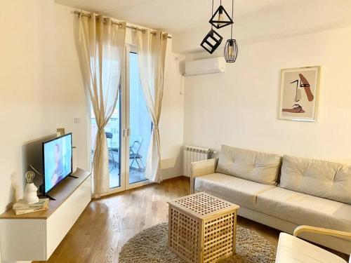 a living room with a couch and a tv at Bright Scandi Apartment in Skopje