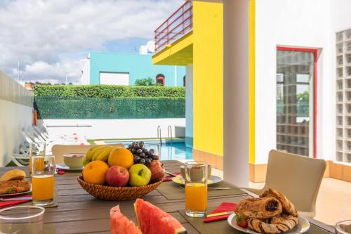 a table with fruit and juice on a balcony at Villa Poseidon by Algarve Vacation in Albufeira