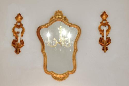 a mirror hanging on a wall with a chandelier at Nordpalais vor Sylt in Emmelsbüll-Horsbüll