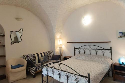 a bedroom with a bed and a couch at Casetta Piazza Emanuele in Cisternino