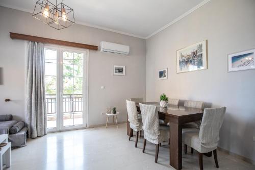 een woonkamer met een houten tafel en stoelen bij Matina's apartment in Póros
