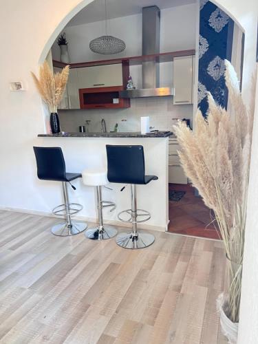 a kitchen with two bar stools and a counter at Casa Victoria in Castelletto sopra Ticino