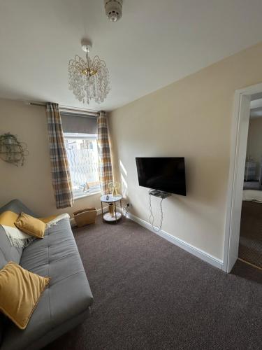 a living room with a couch and a flat screen tv at The Hurstmere in Blackpool