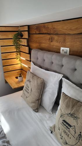 a bedroom with a bed with pillows and a headboard at Hiša stare mame in Kamnik