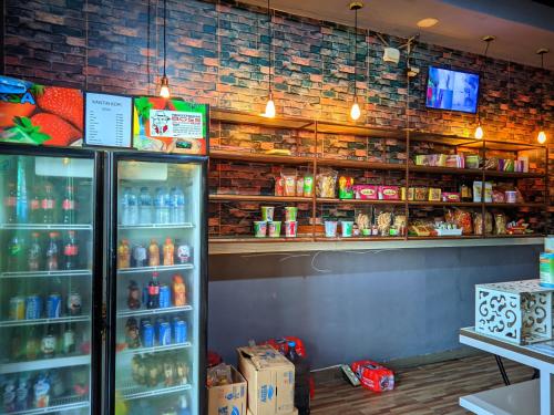a store with a refrigerator and shelves of drinks at Pondok Wisata DEPORIZ 2 in Porisgaga