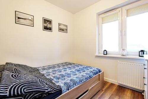 1 dormitorio con cama y ventana en Apartament Kotwica z prywatnym miejscem w hali garażowej, en Świnoujście