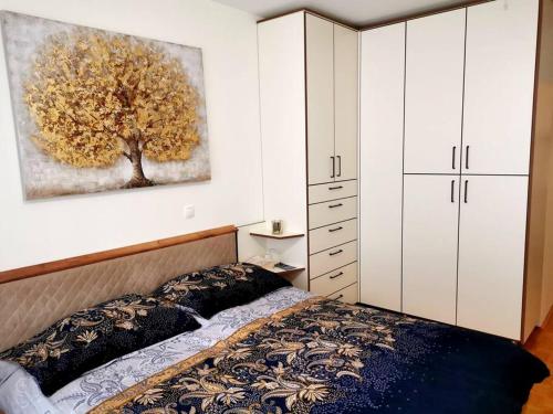 a bedroom with a bed and a painting on the wall at Cozy apartment Ljubljana with free parking and balcony in Ljubljana