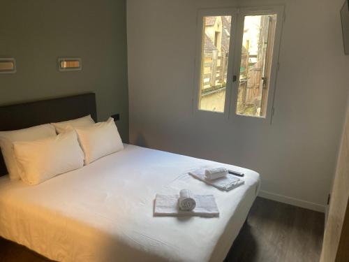 a bedroom with a bed with a tray and a window at Hôtel du Château - Beynac et Cazenac in Beynac-et-Cazenac