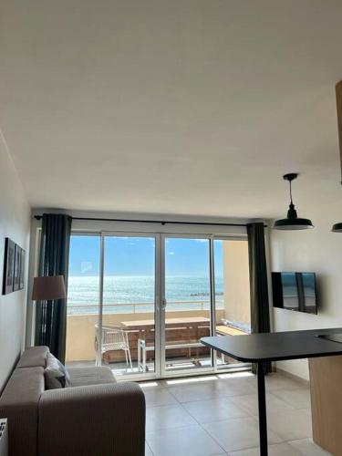 een woonkamer met uitzicht op de oceaan bij Appartement T4 avec vue mer pour 7 personnes in Valras-Plage