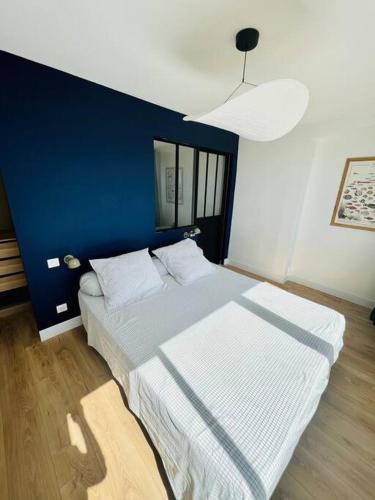 een slaapkamer met een groot bed met een blauwe muur bij Appartement T4 avec vue mer pour 7 personnes in Valras-Plage