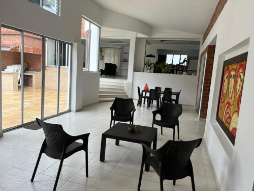 restauracja z czarnymi krzesłami i stołami w pokoju w obiekcie Casa Campestre Sol Naciente w mieście La Tebaida