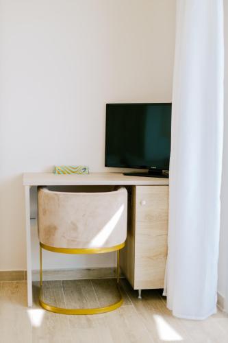 a desk with a television and a chair at The Three Graces in Antimácheia