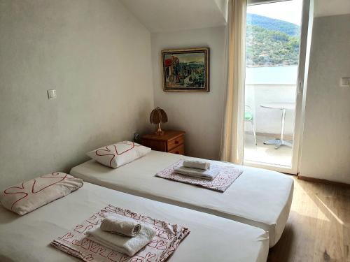 2 Einzelbetten in einem Zimmer mit Fenster in der Unterkunft Casa Naranja Croatia in Vela Luka