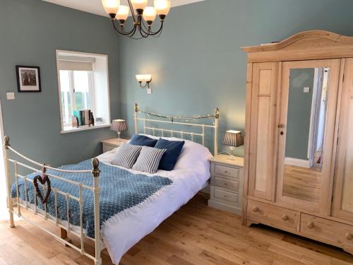 una camera da letto con un letto e una cassettiera di The Little Coach House in Wales a Newtown