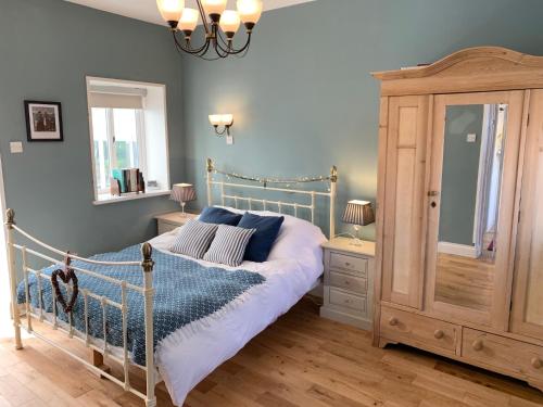 a bedroom with a bed and a dresser at The Little Coach House in Wales in Newtown