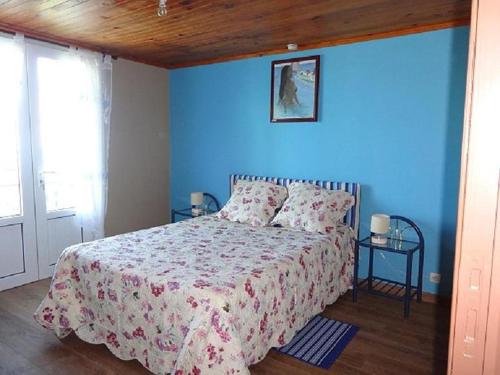 een slaapkamer met een bed met een blauwe muur bij Loca Sun Résidence in Le Guillaume