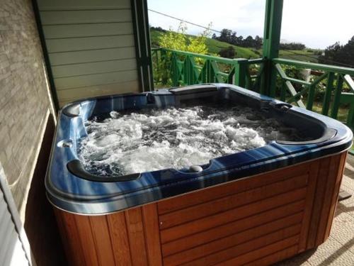 een hot tub op een veranda met water bij Loca Sun Résidence in Le Guillaume