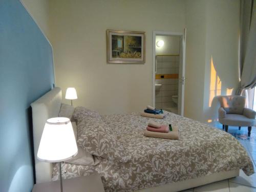 a bedroom with a bed and a lamp and a chair at B&B Villa Rosa Angrisano in Maratea