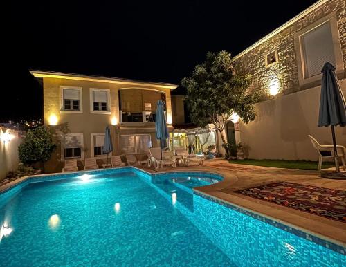 a swimming pool in front of a house at night at Apartments Villa Mike in Mostar
