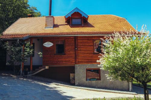 une maison en bois avec un toit rouge dans l'établissement Etno domaćinstvo Milenković, à Despotovac