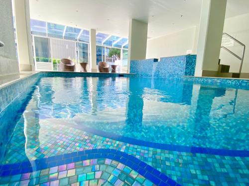 a swimming pool with blue tiles in a building at Ocean View 2BR Main Beach Getaway in Gold Coast