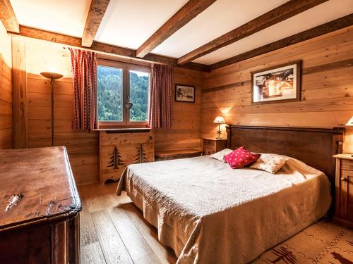 une chambre avec un lit dans une pièce aux murs en bois dans l'établissement Bel appartement 3 ch, calme, garage, Wifi - FR-1-437-18, à La Clusaz