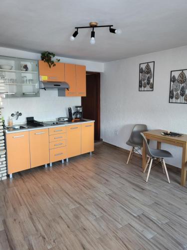 a kitchen with orange cabinets and a wooden table at Licul Apartment in Rovinj