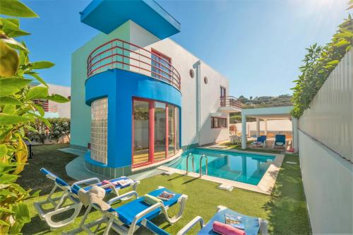 a house with a swimming pool and some chairs at Villa Acapulco by Algarve Vacation in Albufeira