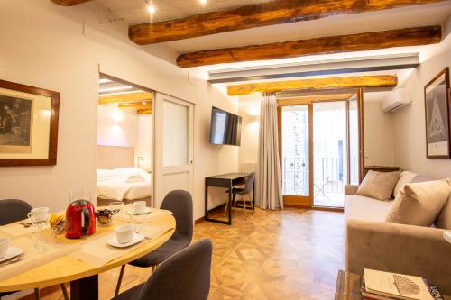 een woonkamer met een tafel en een bank bij Falegnami Boutique Suites - BolognaRooms in Bologna