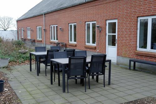 a group of black tables and chairs on a patio at Agervig Bed & Breakfast in Næsbjerg