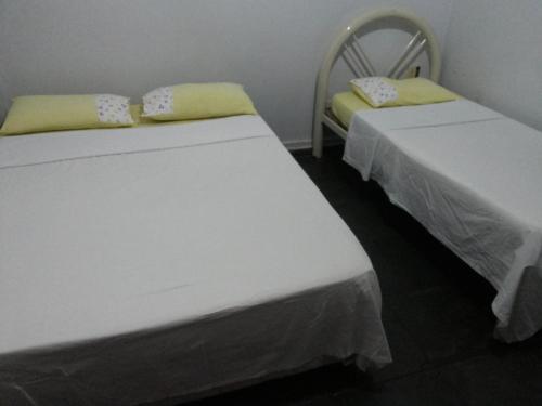 two beds sitting next to each other in a room at Santa Cruz Hotel in Goiânia